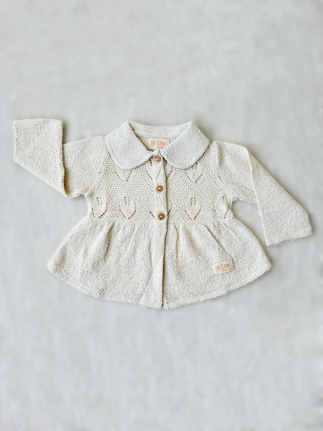 Our Ellen Jacket is the perfect addition to your little girl’s wardrobe! A beautifully crafted knitted jacket with a unique leaf-inspired pattern and captivating rounded flat collar. All in stylish A-fit silhouette with wooden buttons. She’ll look (and feel!) extra special in this elegant and one-of-a-kind piece! Liten Aventuris Colelctions. Bomullsjacka, Barnjacka, Babyjacka.