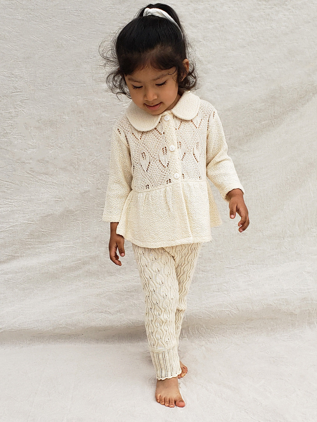 Our Ellen Jacket is the perfect addition to your little girl’s wardrobe! A beautifully crafted knitted jacket with a unique leaf-inspired pattern and captivating rounded flat collar. All in stylish A-fit silhouette with wooden buttons. She’ll look (and feel!) extra special in this elegant and one-of-a-kind piece! Liten Aventuris Colelctions. Bomullsjacka, Barnjacka, Babyjacka.