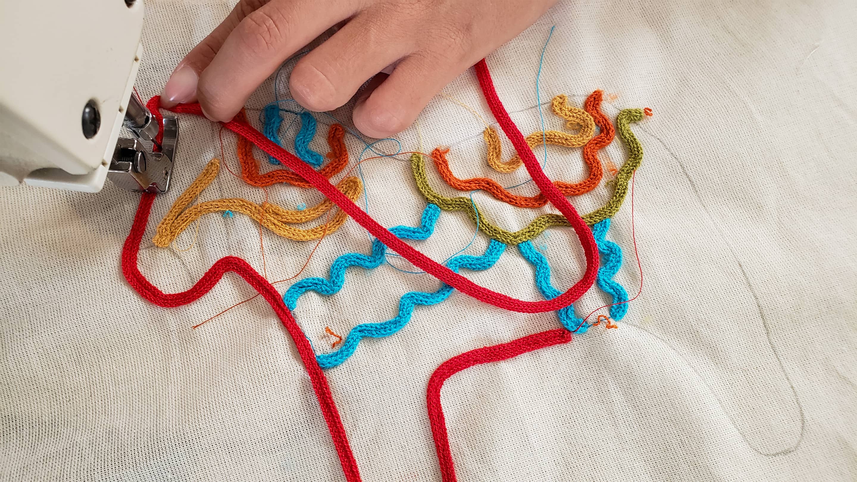 Artisanal embroidery of a Dala horse on a sustainable children's t-shirt by Liten Aventuris. | Hantverksmässig brodyr av en Dalahäst på en hållbar barn t-shirt av Liten Aventuris. | Bordado artesanal de un caballo Dala en una camiseta sostenible para niños de Liten Aventuris.