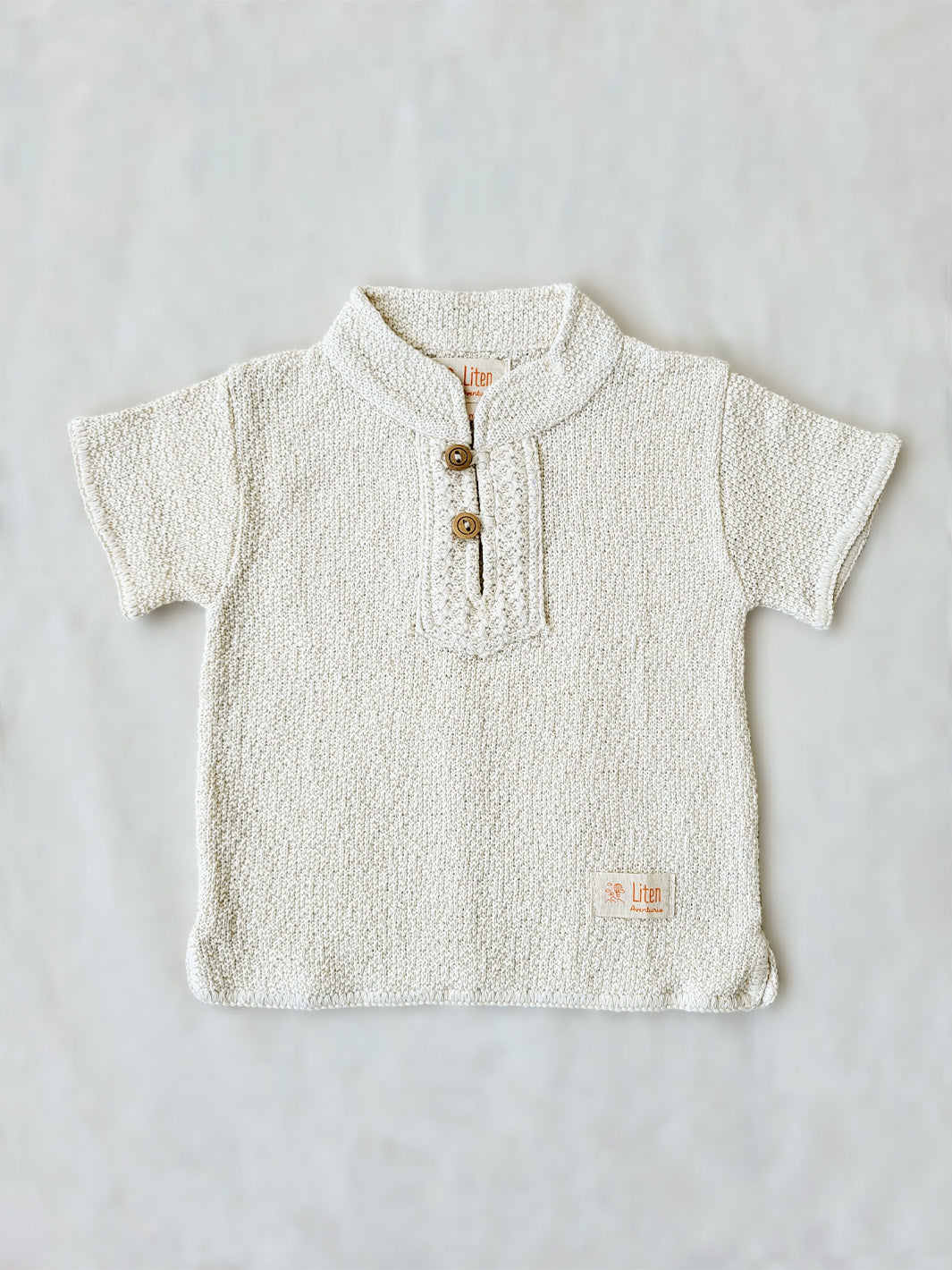 Liten Aventuris Collections. This crafted Luigi Shirt is made of 100% knitted natural Peruvian cotton for a comfortable and lightweight fit. This classic shirt features a mao collar with wooden buttons and a beautifully knitted honeycomb pattern in the opening. It has two apertures on the sides and is finished with knitted trims around the sleeves and base. The loose fit makes it comfortable and perfect for playing. Bomullskläder, barnkläder, Pojken tröja, Skjortor, Natural kläder, ekologisk kläder.