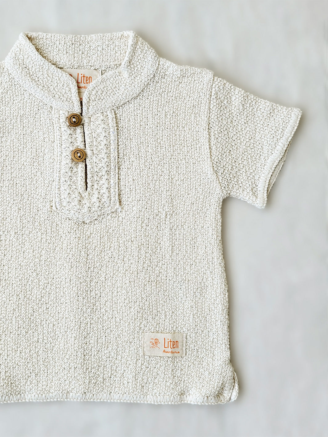 Liten Aventuris Collections. This crafted Luigi Shirt is made of 100% knitted natural Peruvian cotton for a comfortable and lightweight fit. This classic shirt features a mao collar with wooden buttons and a beautifully knitted honeycomb pattern in the opening. It has two apertures on the sides and is finished with knitted trims around the sleeves and base. The loose fit makes it comfortable and perfect for playing. Bomullskläder, barnkläder, Pojken tröja, Skjortor, Natural kläder, ekologisk kläder.