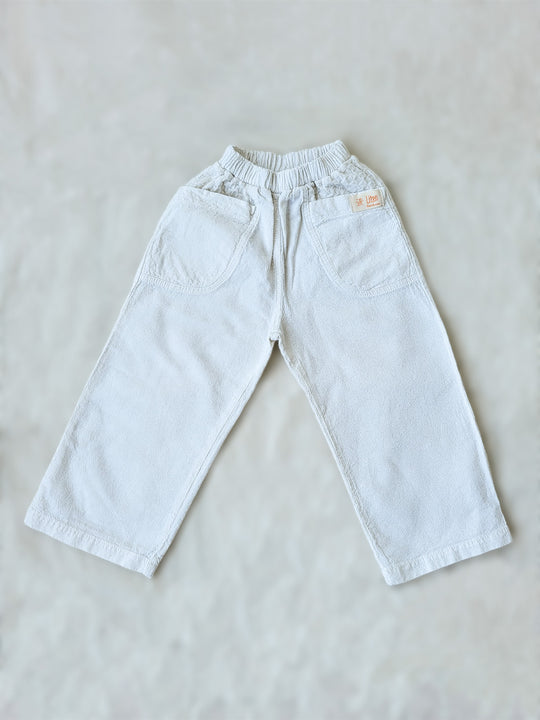 The Olve pants are light and very comfortable. Excellent for traveling or playing outside! These loose-fit pants provide freedom of movement. And the lateral pockets at the front are internally layered with a knitted-cotton pattern. This gives the perfect artisanal touch. Mix and match different outfits with any top from any of our Liten Aventuris collections. Unisex cotton pants. Barnkläder, Bomullskläder, Natural kläder. Flicka, pojken och babis kläder. Barn Byxor.
