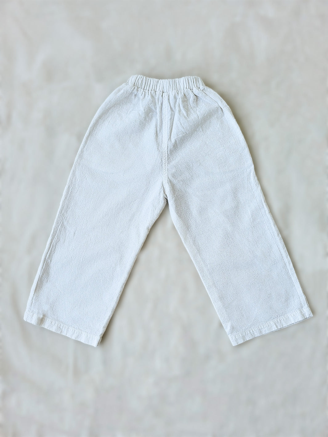 The Olve pants are light and very comfortable. Excellent for traveling or playing outside! These loose-fit pants provide freedom of movement. And the lateral pockets at the front are internally layered with a knitted-cotton pattern. This gives the perfect artisanal touch. Mix and match different outfits with any top from any of our Liten Aventuris collections. Unisex cotton pants. Barnkläder, Bomullskläder, Natural kläder. Flicka, pojken och babis kläder. Barn Byxor.
