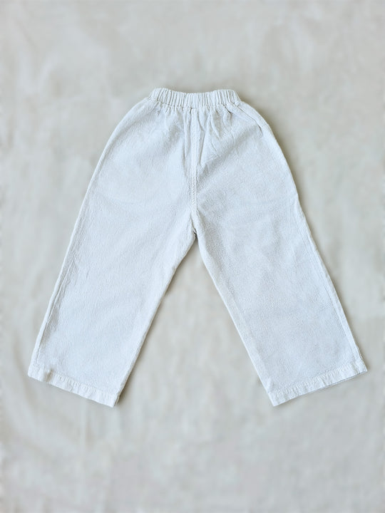 The Olve pants are light and very comfortable. Excellent for traveling or playing outside! These loose-fit pants provide freedom of movement. And the lateral pockets at the front are internally layered with a knitted-cotton pattern. This gives the perfect artisanal touch. Mix and match different outfits with any top from any of our Liten Aventuris collections. Unisex cotton pants. Barnkläder, Bomullskläder, Natural kläder. Flicka, pojken och babis kläder. Barn Byxor.