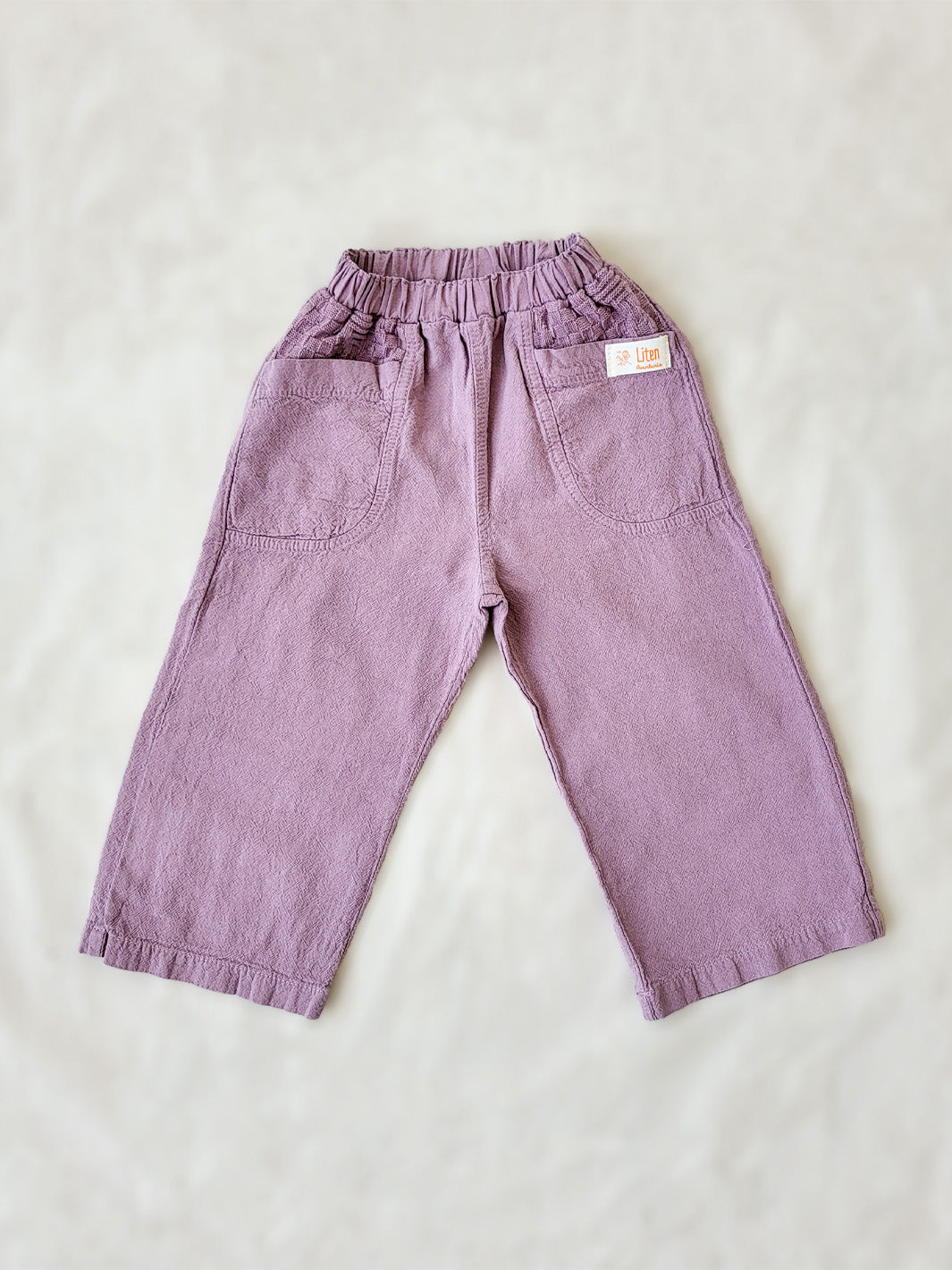 The Olve pants are light and very comfortable. Excellent for traveling or playing outside! These loose-fit pants provide freedom of movement. And the lateral pockets at the front are internally layered with a knitted-cotton pattern. This gives the perfect artisanal touch. Mix and match different outfits with any top from any of our Liten Aventuris collections. Unisex cotton pants. Barnkläder, Bomullskläder, Natural kläder. Flicka, pojken och babis kläder. Barn Byxor.