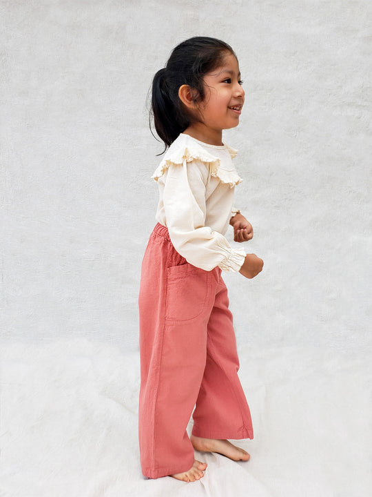 The Olve pants are light and very comfortable. Excellent for traveling or playing outside! These loose-fit pants provide freedom of movement. And the lateral pockets at the front are internally layered with a knitted-cotton pattern. This gives the perfect artisanal touch. Mix and match different outfits with any top from any of our Liten Aventuris collections. Unisex cotton pants. Barnkläder, Bomullskläder, Natural kläder. Flicka, pojken och babis kläder. Barn Byxor.