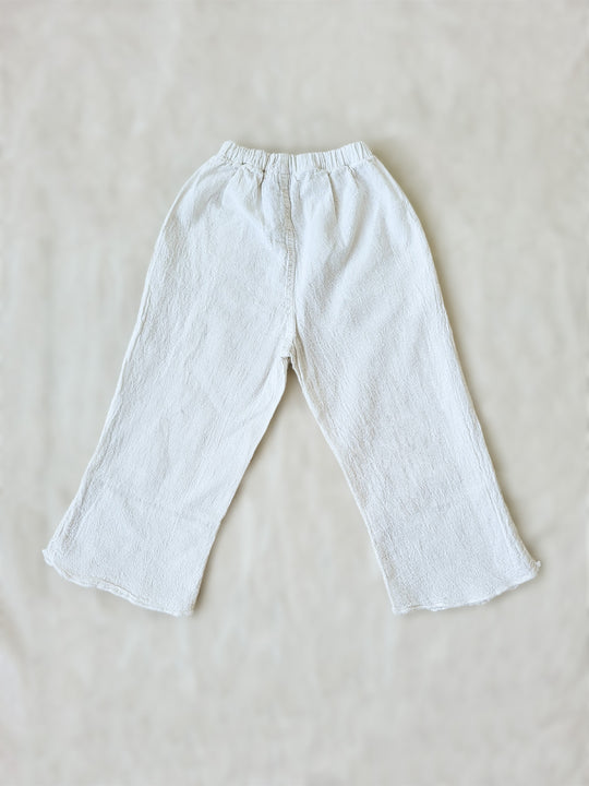 Liten Aventuris brand. Keep your little girl comfy and stylish in our Annie Pants! These natural cotton pants feature playful knitted cotton patterns at the bottom for added breeziness. With front pockets for keeping those special treasures! The soft material will keep your young one feeling silky. Pair this loose-fitting design with our Annie Blouse for the perfect winning combo! Flickan Byxor, Barns bomullskläder, svenska kläder, flickans byxor, ekologisk kläder, babis byxor.