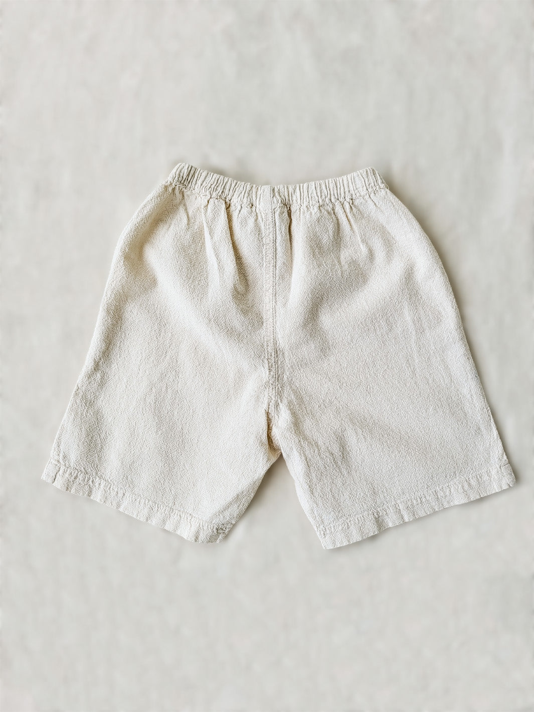Liten Aventuris Natural Tocuyo Cotton shorts for kids. Our Niko shorts are perfect for exploring outside. With its loose-fitting size and soft elastic on the waist, toddlers and kids will feel comfortable and free. Perfect for boys and girls. Barnkläder, Bomullskläder, Natural kläder. Flicka och pojken kläder. Barn kortbyxor, byxor, .byxa.