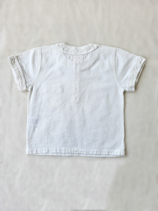 The wide-fit short sleeve Marco shirt is great for adventures! With its Tunisian collar covered in coconut buttons and decorative knitted cotton pattern, this shirt is perfect for chic and casual summer days. This bonny shirt has a front pocket where kids can save their most valuable treasures. Liten Aventuris. Ethically made in Peru. Bomullskläder, barnkläder, Pojken tröja, Skjortor, Natural kläder, ekologisk kläder.