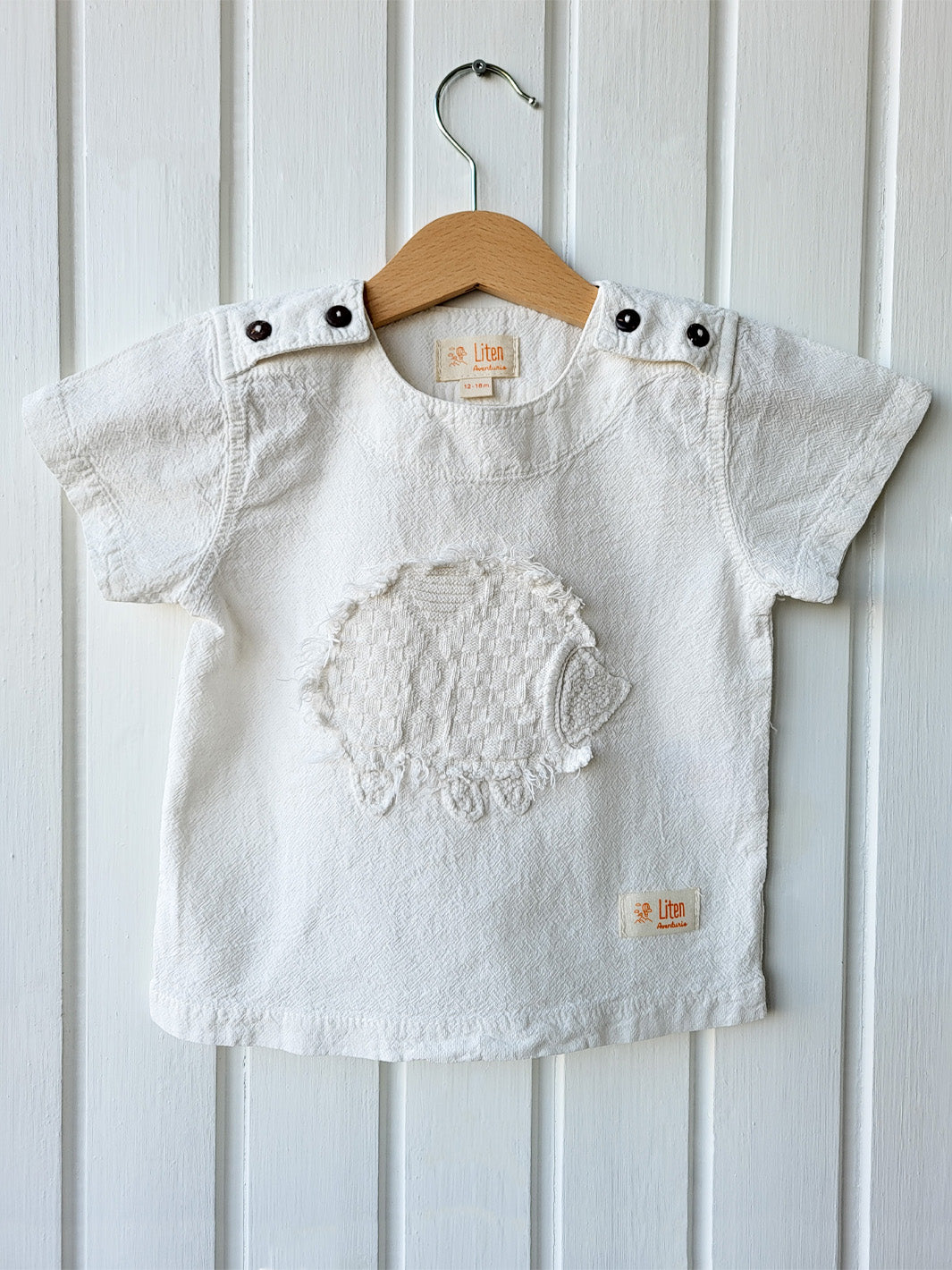 Liten Aventuris Natural Tocuyo Cotton t-shirt for kids. Kirpi is a cute little porcupine embroidered in knitted natural tanguis cotton. Our skilled artisans handcrafted Kirpi with care and attention to detail. Our lovely Kirpi T-shirt is a loose-fitting garment with coconut buttons. The opening on the shoulders makes the kid more comfortable when dressing up. Ethically made in Peru. Bomullskläder, barnkläder, Pojken & flickan tröja, Natural kläder, ekologisk kläder. Skjortor.