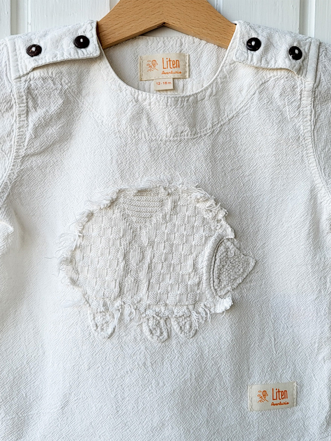 Liten Aventuris Natural Tocuyo Cotton t-shirt for kids. Kirpi is a cute little porcupine embroidered in knitted natural tanguis cotton. Our skilled artisans handcrafted Kirpi with care and attention to detail. Our lovely Kirpi T-shirt is a loose-fitting garment with coconut buttons. The opening on the shoulders makes the kid more comfortable when dressing up. Ethically made in Peru. Bomullskläder, barnkläder, Pojken & flickan tröja, Natural kläder, ekologisk kläder. Skjortor.