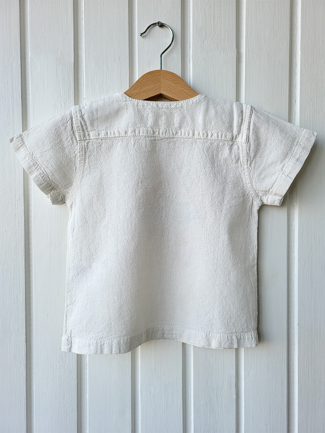 Liten Aventuris Natural Tocuyo Cotton t-shirt for kids. Kirpi is a cute little porcupine embroidered in knitted natural tanguis cotton. Our skilled artisans handcrafted Kirpi with care and attention to detail. Our lovely Kirpi T-shirt is a loose-fitting garment with coconut buttons. The opening on the shoulders makes the kid more comfortable when dressing up. Ethically made in Peru. Bomullskläder, barnkläder, Pojken & flickan tröja, Natural kläder, ekologisk kläder. Skjortor.