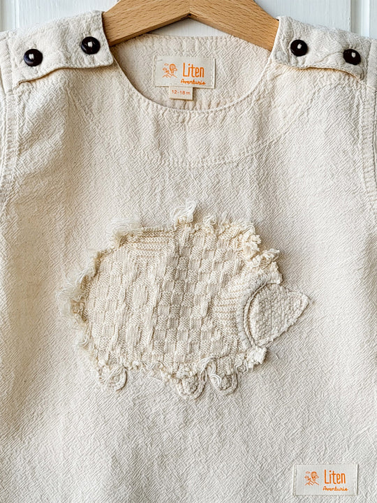 Liten Aventuris Natural Tocuyo Cotton t-shirt for kids. Kirpi is a cute little porcupine embroidered in knitted natural tanguis cotton. Our skilled artisans handcrafted Kirpi with care and attention to detail. Our lovely Kirpi T-shirt is a loose-fitting garment with coconut buttons. The opening on the shoulders makes the kid more comfortable when dressing up. Ethically made in Peru. Bomullskläder, barnkläder, Pojken & flickan tröja, Natural kläder, ekologisk kläder. Skjortor.