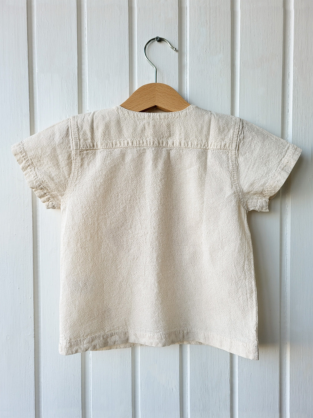 Liten Aventuris Natural Tocuyo Cotton t-shirt for kids. Kirpi is a cute little porcupine embroidered in knitted natural tanguis cotton. Our skilled artisans handcrafted Kirpi with care and attention to detail. Our lovely Kirpi T-shirt is a loose-fitting garment with coconut buttons. The opening on the shoulders makes the kid more comfortable when dressing up. Ethically made in Peru. Bomullskläder, barnkläder, Pojken & flickan tröja, Natural kläder, ekologisk kläder. Skjortor.