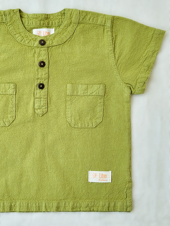 Liten Aventuris Natural Tocuyo Cotton shirt for kids. The Philipo shirt is perfect for a picnic at a lake or a nice morning stroll! This short sleeve shirt with coconut buttons and tunisian collar is casual and chic at the same time. This loose-fitting shirt with two pockets, is comfortable and soft with the skin. Ethically made in Peru. Bomullskläder, barnkläder, Pojken tröja, Natural kläder, ekologisk kläder. Skjortor.