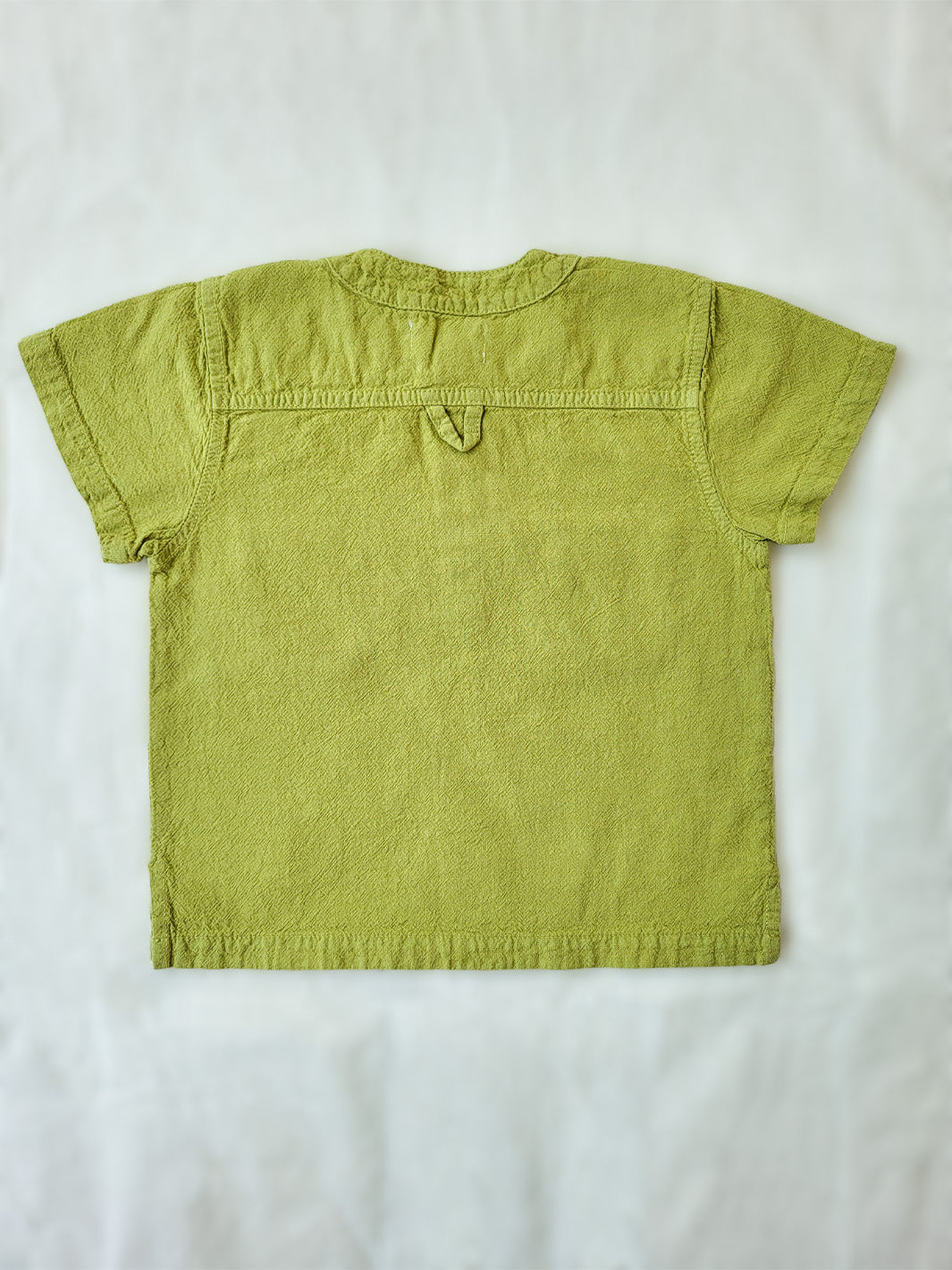 Liten Aventuris Natural Tocuyo Cotton shirt for kids. The Philipo shirt is perfect for a picnic at a lake or a nice morning stroll! This short sleeve shirt with coconut buttons and tunisian collar is casual and chic at the same time. This loose-fitting shirt with two pockets, is comfortable and soft with the skin. Ethically made in Peru. Bomullskläder, barnkläder, Pojken tröja, Natural kläder, ekologisk kläder. Skjortor.
