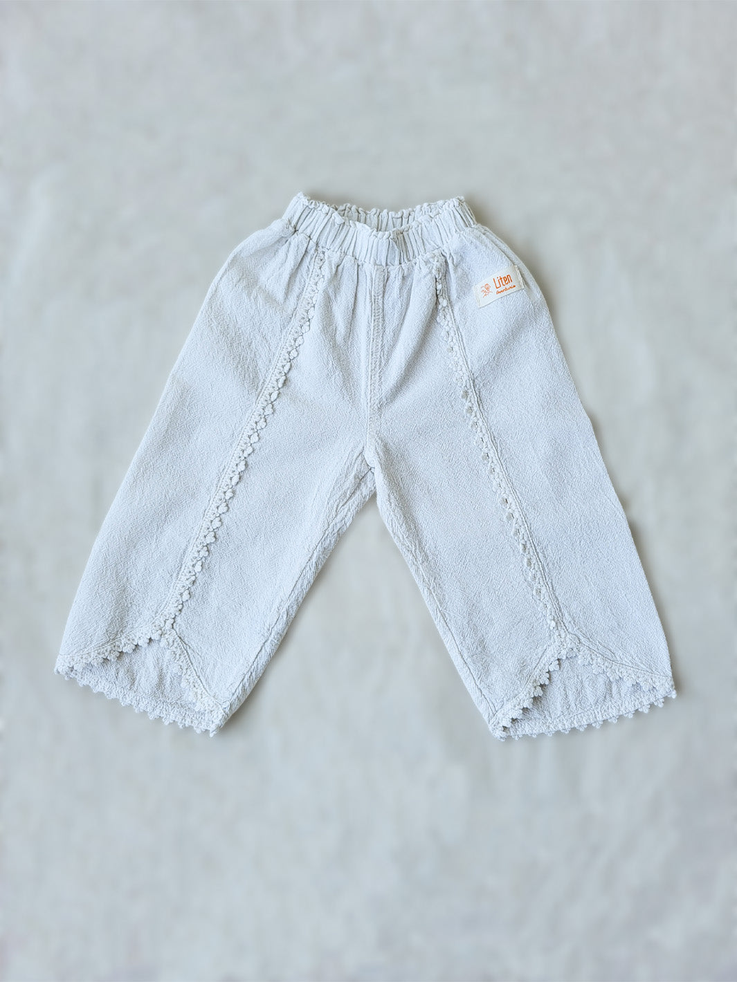 Liten Aventuris Natural Tocuyo Cotton pants for kids. Our Lorin pants are perfect for sunny days. With its loose-fitting size and soft elastic on the waist, toddlers and kids will feel comfortable and free. The Lorin pants bring an embroidered cotton decorative ribbon that will be the perfect match to our Lorin T-shirt! Perfect for girls. Barnkläder, Bomullskläder, Natural kläder. Flicka kläder. Barn Byxor.