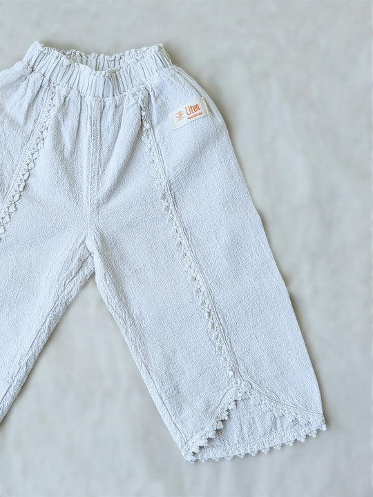 Liten Aventuris Natural Tocuyo Cotton pants for kids. Our Lorin pants are perfect for sunny days. With its loose-fitting size and soft elastic on the waist, toddlers and kids will feel comfortable and free. The Lorin pants bring an embroidered cotton decorative ribbon that will be the perfect match to our Lorin T-shirt! Perfect for girls. Barnkläder, Bomullskläder, Natural kläder. Flicka kläder. Barn Byxor.