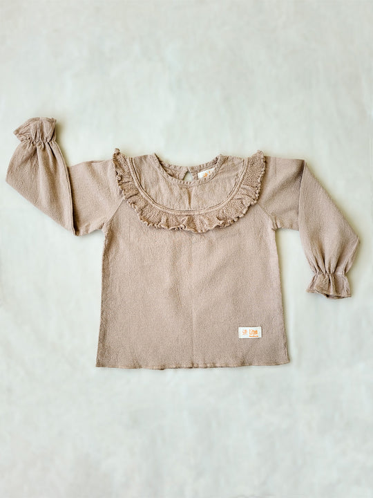 Liten Aventuris. Our Siri Blouse is elegant and comfortable at the same time. Its long sleeves with ruffles on the wrists are perfect for an evening stroll. The knitted cotton ruffles on the chest add a nice artisanal touch. Part of our Collection. Loose-fitting garment. 100% Flat-knitted Natural Peruvian Tocuyo Cotton. 100% knitted Natural Tanguis Cotton. Ethically made in Peru. Perfect for girls. Barnkläder, Bomullskläder, Natural kläder. Flicka kläder. Flickblus. Barnblus.