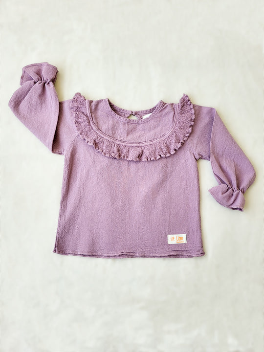 Liten Aventuris. Our Siri Blouse is elegant and comfortable at the same time. Its long sleeves with ruffles on the wrists are perfect for an evening stroll. The knitted cotton ruffles on the chest add a nice artisanal touch. Part of our Collection. Loose-fitting garment. 100% Flat-knitted Natural Peruvian Tocuyo Cotton. 100% knitted Natural Tanguis Cotton. Ethically made in Peru. Perfect for girls. Barnkläder, Bomullskläder, Natural kläder. Flicka kläder. Flickblus. Barnblus.