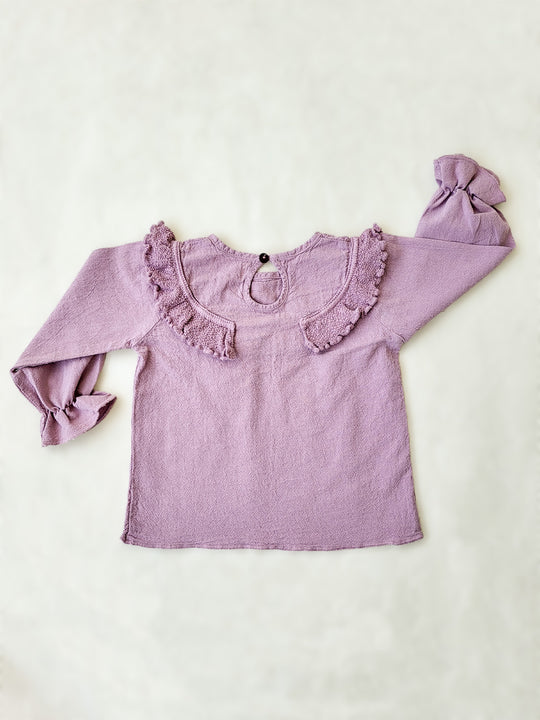 Liten Aventuris. Our Siri Blouse is elegant and comfortable at the same time. Its long sleeves with ruffles on the wrists are perfect for an evening stroll. The knitted cotton ruffles on the chest add a nice artisanal touch. Part of our Collection. Loose-fitting garment. 100% Flat-knitted Natural Peruvian Tocuyo Cotton. 100% knitted Natural Tanguis Cotton. Ethically made in Peru. Perfect for girls. Barnkläder, Bomullskläder, Natural kläder. Flicka kläder. Flickblus. Barnblus.