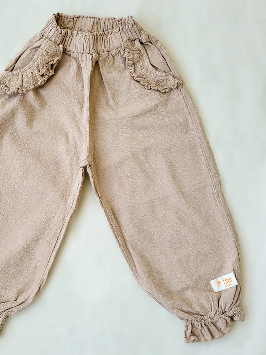 The Siri Pants are elegant and comfortable at the same time. These bloomer pants with ruffles at the bottom are perfect for a walk on the beach or a nice play date at the park. The Siri Pants bring two pockets with knitted cotton ruffles on them. It adds a nice artisanal touch. Beautiful, chic, and charming! Make the perfect match with the Siri blouse. 100% Natural Peruvian Tocuyo Cotton. Perfect for girls. Barnkläder, Bomullskläder, Natural kläder. Flicka kläder. Barn Byxor.