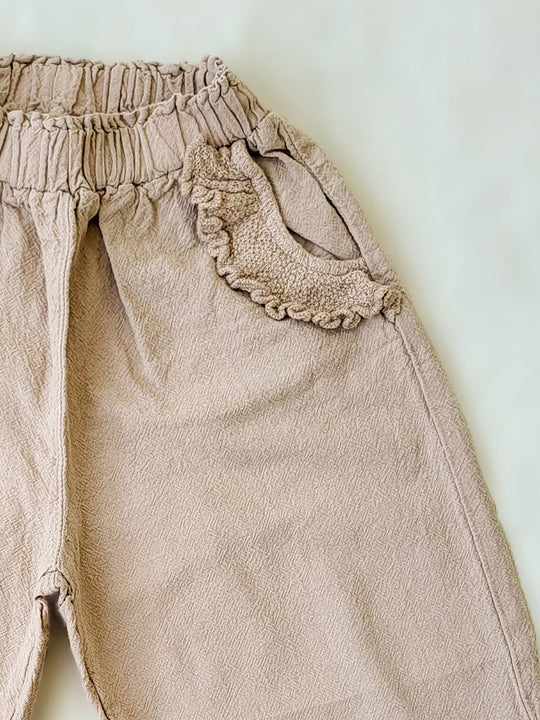 The Siri Pants are elegant and comfortable at the same time. These bloomer pants with ruffles at the bottom are perfect for a walk on the beach or a nice play date at the park. The Siri Pants bring two pockets with knitted cotton ruffles on them. It adds a nice artisanal touch. Beautiful, chic, and charming! Make the perfect match with the Siri blouse. 100% Natural Peruvian Tocuyo Cotton. Perfect for girls. Barnkläder, Bomullskläder, Natural kläder. Flicka kläder. Barn Byxor.