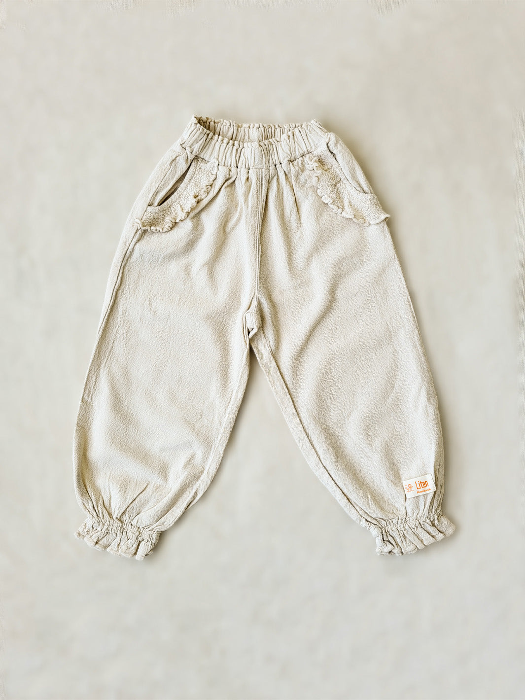 The Siri Pants are elegant and comfortable at the same time. These bloomer pants with ruffles at the bottom are perfect for a walk on the beach or a nice play date at the park. The Siri Pants bring two pockets with knitted cotton ruffles on them. It adds a nice artisanal touch. Beautiful, chic, and charming! Make the perfect match with the Siri blouse. 100% Natural Peruvian Tocuyo Cotton. Perfect for girls. Barnkläder, Bomullskläder, Natural kläder. Flicka kläder. Barn Byxor.