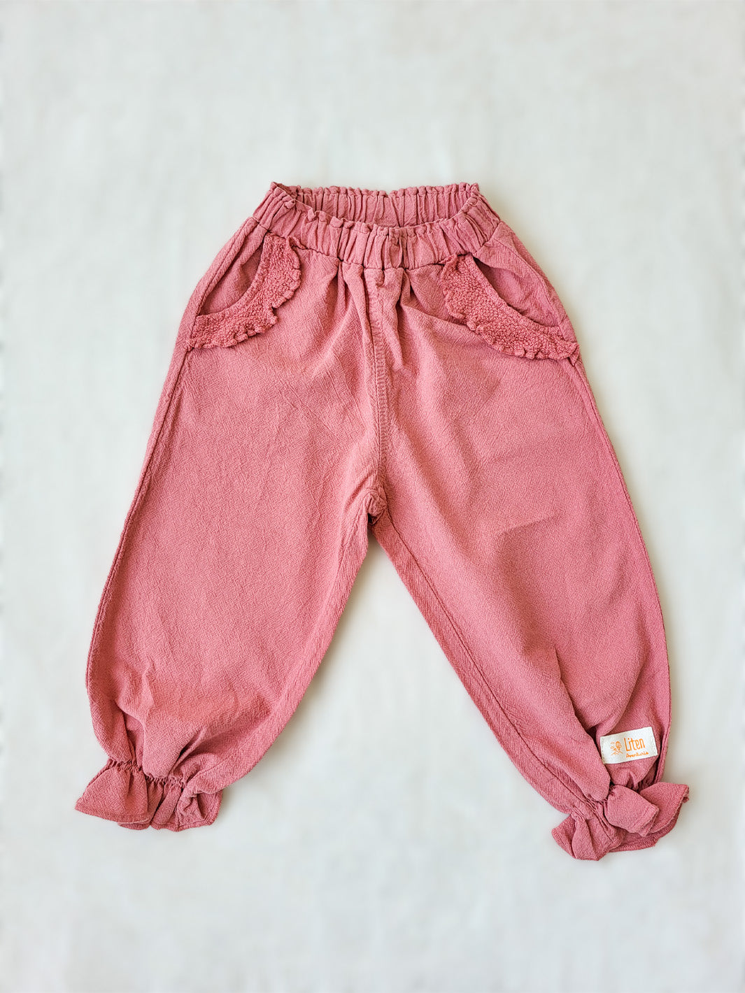 The Siri Pants are elegant and comfortable at the same time. These bloomer pants with ruffles at the bottom are perfect for a walk on the beach or a nice play date at the park. The Siri Pants bring two pockets with knitted cotton ruffles on them. It adds a nice artisanal touch. Beautiful, chic, and charming! Make the perfect match with the Siri blouse. 100% Natural Peruvian Tocuyo Cotton. Perfect for girls. Barnkläder, Bomullskläder, Natural kläder. Flicka kläder. Barn Byxor.