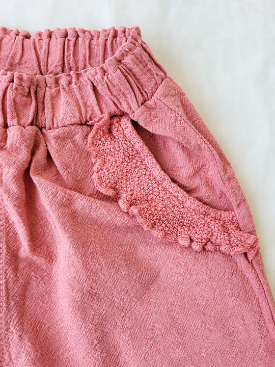 The Siri Pants are elegant and comfortable at the same time. These bloomer pants with ruffles at the bottom are perfect for a walk on the beach or a nice play date at the park. The Siri Pants bring two pockets with knitted cotton ruffles on them. It adds a nice artisanal touch. Beautiful, chic, and charming! Make the perfect match with the Siri blouse. 100% Natural Peruvian Tocuyo Cotton. Perfect for girls. Barnkläder, Bomullskläder, Natural kläder. Flicka kläder. Barn Byxor.