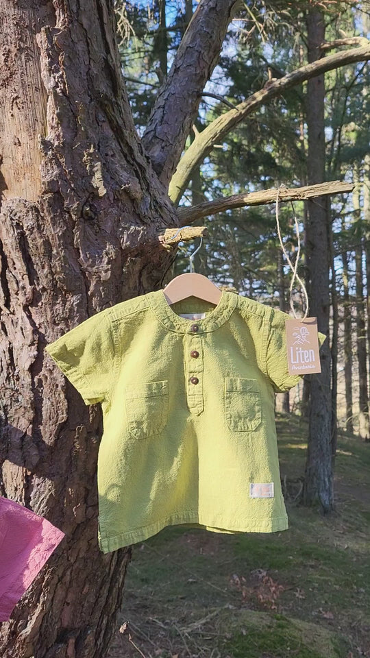 Liten Aventuris Natural Tocuyo Cotton shirt for kids. The Philipo shirt is perfect for a picnic at a lake or a nice morning stroll! This short sleeve shirt with coconut buttons and tunisian collar is casual and chic at the same time. This loose-fitting shirt with two pockets, is comfortable and soft with the skin. Ethically made in Peru. Bomullskläder, barnkläder, Pojken tröja, Natural kläder, ekologisk kläder. Skjortor.