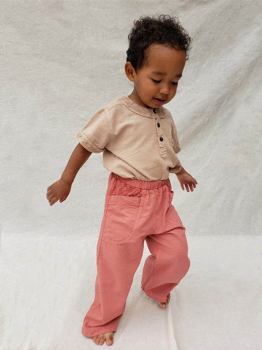 The Olve pants are light and very comfortable. Excellent for traveling or playing outside! These loose-fit pants provide freedom of movement. And the lateral pockets at the front are internally layered with a knitted-cotton pattern. This gives the perfect artisanal touch. Mix and match different outfits with any top from any of our Liten Aventuris collections. Unisex cotton pants. Barnkläder, Bomullskläder, Natural kläder. Flicka, pojken och babis kläder. Barn Byxor.