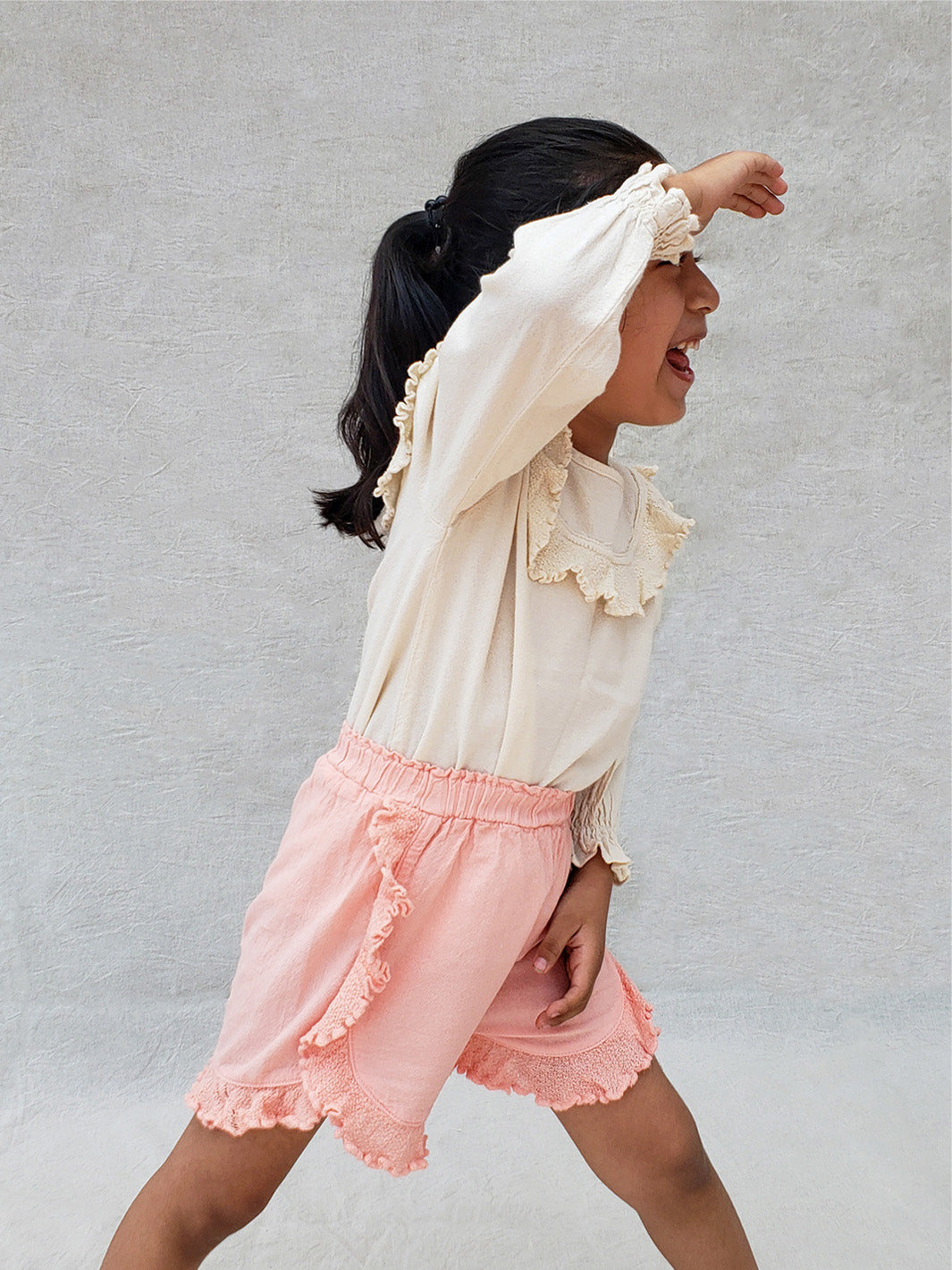 The beautiful Linn shorts are a wide-fit style. Perfect for climbing up trees or going on an adventure in the forest. Its lightweight cotton-knitted ruffles give the perfect light and artisanal touch. Flicka, Barn och Babis kläder. Barn kortbyxor, byxor, byxa. Combine with any other top from anny of our Liten Aventuris collections.