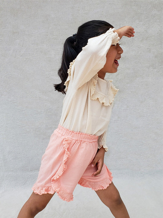 The beautiful Linn shorts are a wide-fit style. Perfect for climbing up trees or going on an adventure in the forest. Its lightweight cotton-knitted ruffles give the perfect light and artisanal touch. Flicka, Barn och Babis kläder. Barn kortbyxor, byxor, byxa. Combine with any other top from anny of our Liten Aventuris collections.