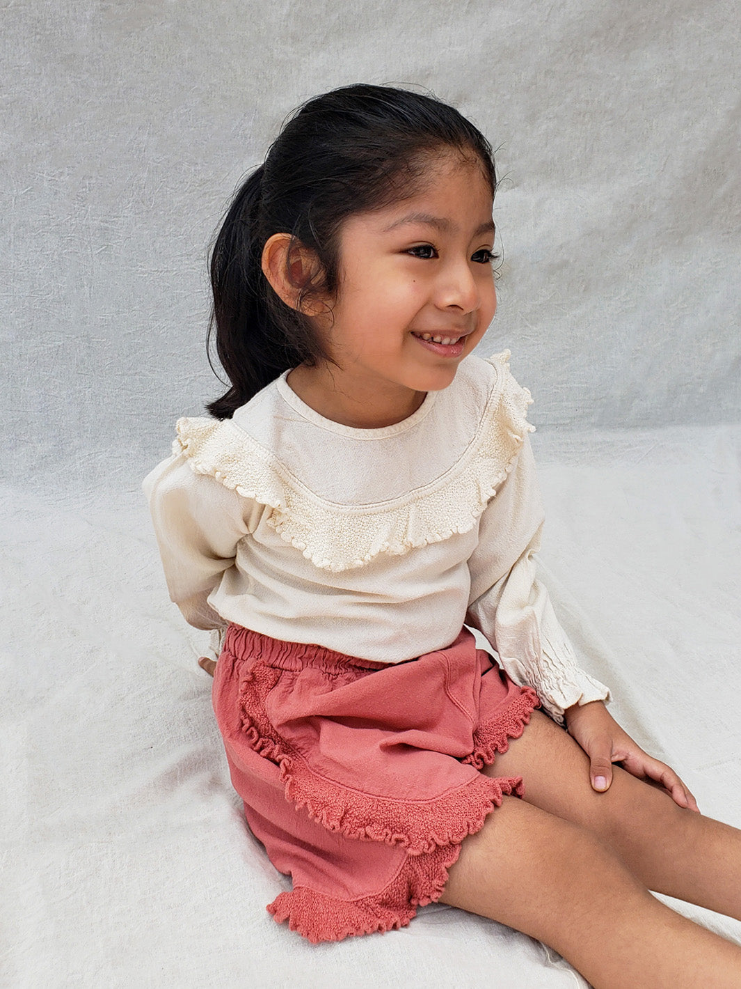 The beautiful Linn shorts are a wide-fit style. Perfect for climbing up trees or going on an adventure in the forest. Its lightweight cotton-knitted ruffles give the perfect light and artisanal touch. Flicka, Barn och Babis kläder. Barn kortbyxor, byxor, byxa. Combine with any other top from anny of our Liten Aventuris collections.