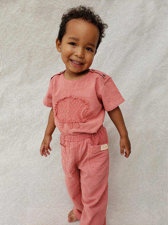 Liten Aventuris Natural Tocuyo Cotton t-shirt for kids. Kirpi is a cute little porcupine embroidered in knitted natural tanguis cotton. Our skilled artisans handcrafted Kirpi with care and attention to detail. Our lovely Kirpi T-shirt is a loose-fitting garment with coconut buttons. The opening on the shoulders makes the kid more comfortable when dressing up. Ethically made in Peru. Bomullskläder, barnkläder, Pojken & flickan tröja, Natural kläder, ekologisk kläder. Skjortor.