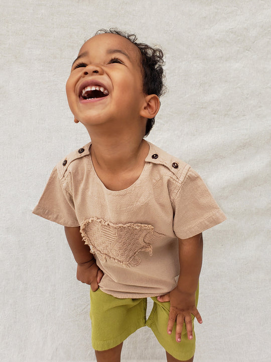 Liten Aventuris Natural Tocuyo Cotton t-shirt for kids. Kirpi is a cute little porcupine embroidered in knitted natural tanguis cotton. Our skilled artisans handcrafted Kirpi with care and attention to detail. Our lovely Kirpi T-shirt is a loose-fitting garment with coconut buttons. The opening on the shoulders makes the kid more comfortable when dressing up. Ethically made in Peru. Bomullskläder, barnkläder, Pojken & flickan tröja, Natural kläder, ekologisk kläder. Skjortor.