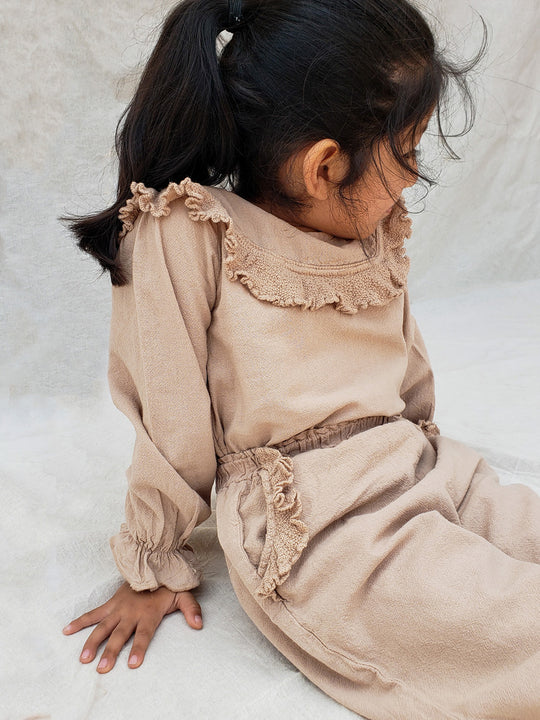 Liten Aventuris. Our Siri Blouse is elegant and comfortable at the same time. Its long sleeves with ruffles on the wrists are perfect for an evening stroll. The knitted cotton ruffles on the chest add a nice artisanal touch. Part of our Collection. Loose-fitting garment. 100% Flat-knitted Natural Peruvian Tocuyo Cotton. 100% knitted Natural Tanguis Cotton. Ethically made in Peru. Perfect for girls. Barnkläder, Bomullskläder, Natural kläder. Flicka kläder. Flickblus. Barnblus.